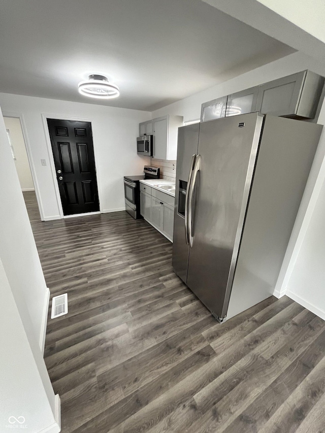 3201 W 22nd St, Indianapolis, IN 46222 - kitchen featuring stainless steel appliances, dark wood-style floors, light countertops, and gray cabinets