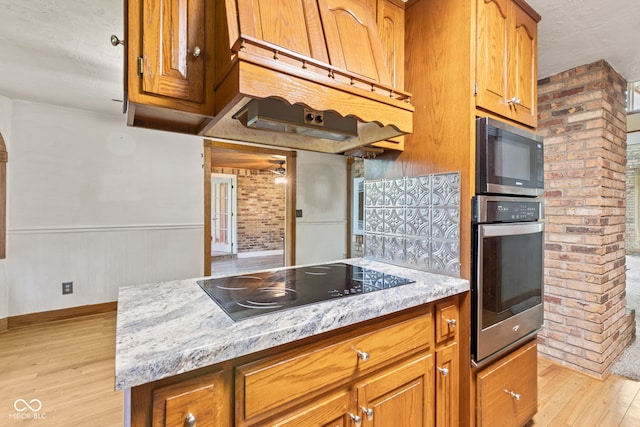 396 W 500 S, Anderson, IN 46013 - kitchen featuring black appliances, light wood-style floors, brown cabinets, a textured ceiling, and light stone countertops