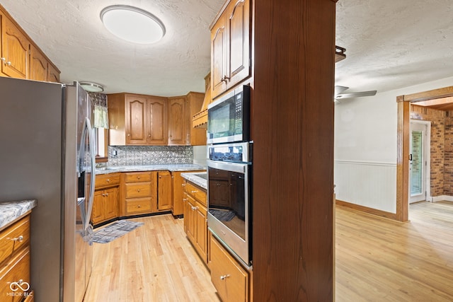 396 W 500 S, Anderson, IN 46013 - kitchen featuring stainless steel appliances, a textured ceiling, light wood finished floors, brown cabinets, and tasteful backsplash