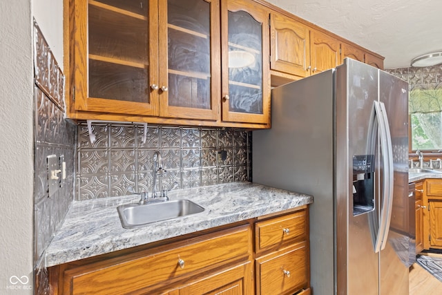 396 W 500 S, Anderson, IN 46013 - kitchen featuring stainless steel fridge, backsplash, glass insert cabinets, and brown cabinetry
