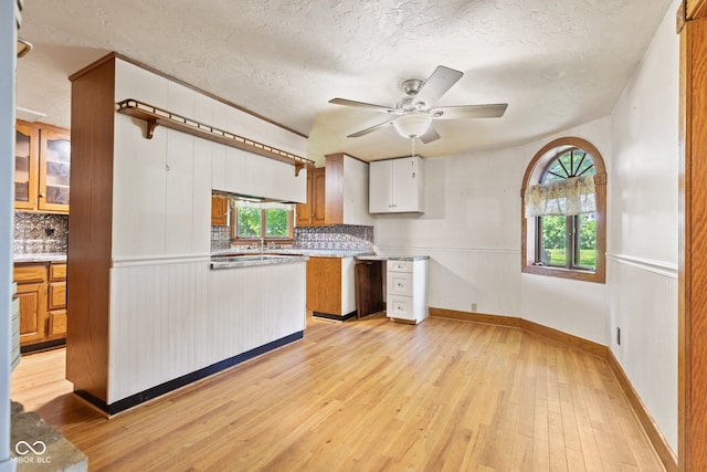 396 W 500 S, Anderson, IN 46013 - kitchen with tasteful backsplash, light wood-style floors, a textured ceiling, a ceiling fan, and brown cabinetry