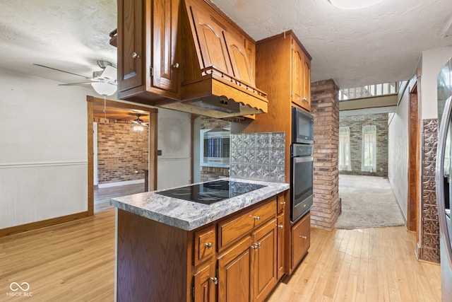 396 W 500 S, Anderson, IN 46013 - kitchen with black appliances, light wood-type flooring, a ceiling fan, brown cabinetry, and brick wall