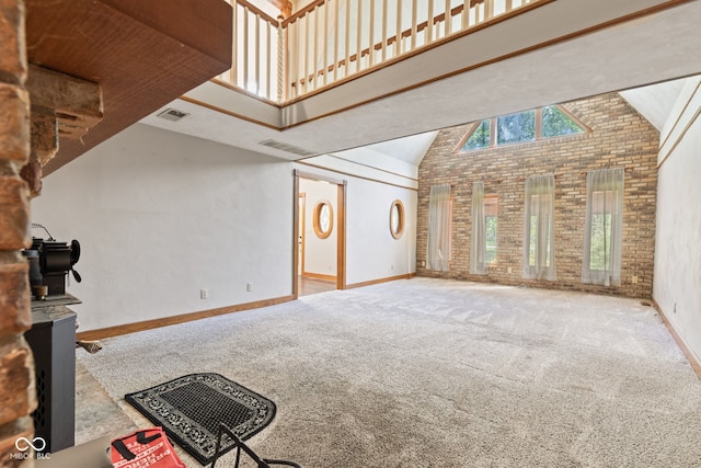 396 W 500 S, Anderson, IN 46013 - unfurnished living room featuring high vaulted ceiling, carpet floors, and brick wall