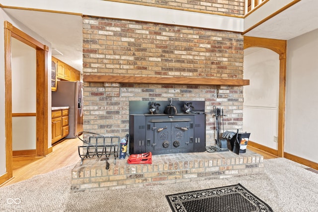 396 W 500 S, Anderson, IN 46013 - detailed view of stainless steel refrigerator with ice dispenser, wood finished floors, and a wood stove