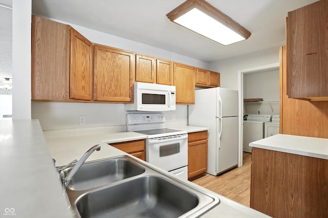 5003 Opal Ridge Ln Unit 101, Indianapolis, IN 46237 - kitchen with white appliances, washing machine and clothes dryer, light wood finished floors, and light countertops