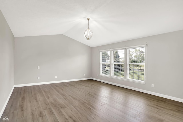 3345 Kilkenny Cir, Carmel, IN 46032 - unfurnished room with a chandelier, vaulted ceiling, and wood finished floors