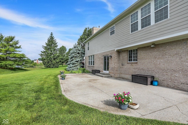 3345 Kilkenny Cir, Carmel, IN 46032 - rear view of property with a patio area, a chimney, a lawn, brick siding, and entry steps