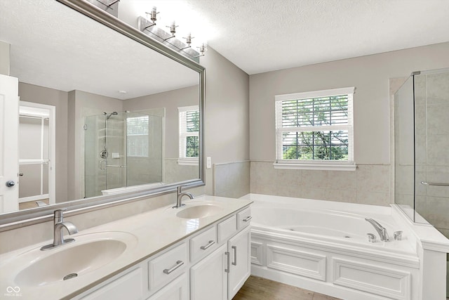 3345 Kilkenny Cir, Carmel, IN 46032 - bathroom featuring a bath, double vanity, a shower stall, a textured ceiling, and wood finished floors