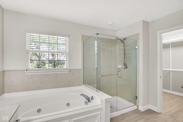 3345 Kilkenny Cir, Carmel, IN 46032 - bathroom featuring a whirlpool tub, a stall shower, wood finished floors, and a walk in closet
