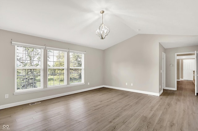 3345 Kilkenny Cir, Carmel, IN 46032 - spare room with a chandelier, wood finished floors, and lofted ceiling