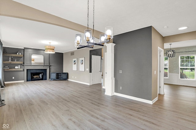 3345 Kilkenny Cir, Carmel, IN 46032 - unfurnished living room featuring a chandelier, light wood-style flooring, and a fireplace
