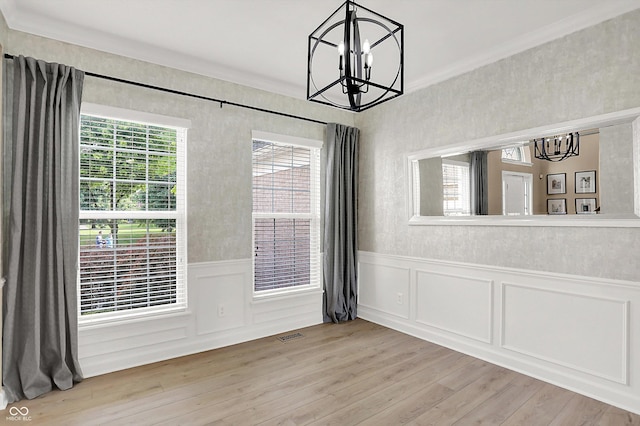 3345 Kilkenny Cir, Carmel, IN 46032 - unfurnished dining area featuring a chandelier, healthy amount of natural light, crown molding, light wood-style floors, and a wainscoted wall