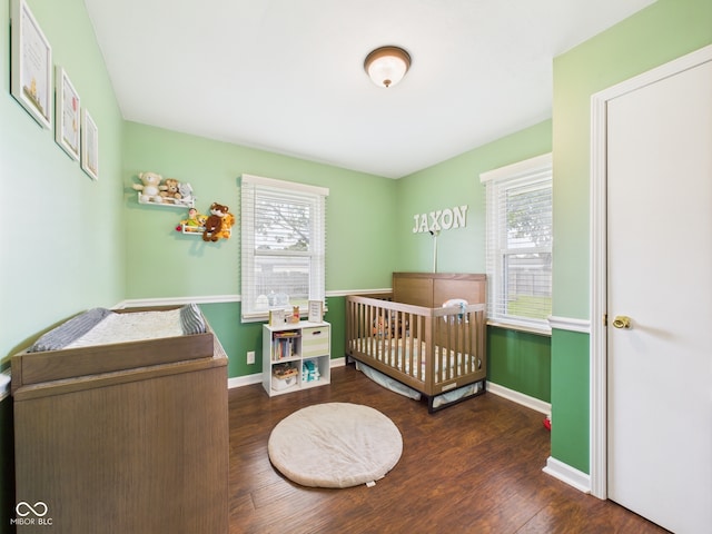 3809 N Glenwood Ave, Muncie, IN 47304 - bedroom with multiple windows, wood finished floors, and a crib