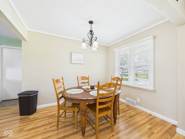 3809 N Glenwood Ave, Muncie, IN 47304 - dining space featuring crown molding, light wood-type flooring, a chandelier, and a textured ceiling