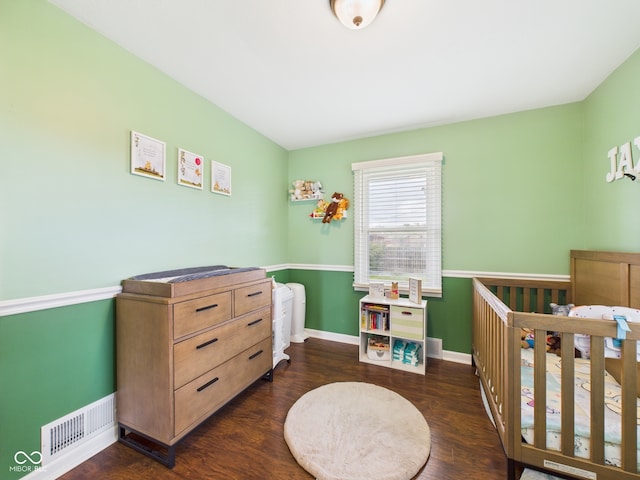 3809 N Glenwood Ave, Muncie, IN 47304 - bedroom featuring dark wood finished floors and a nursery area
