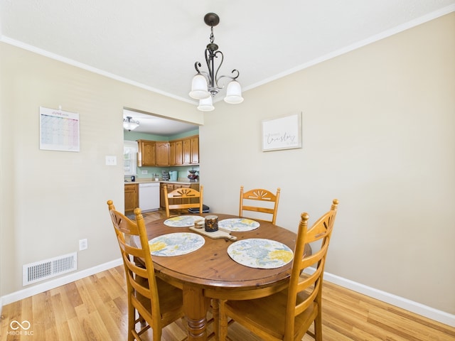 3809 N Glenwood Ave, Muncie, IN 47304 - dining area featuring light wood finished floors, a chandelier, and crown molding