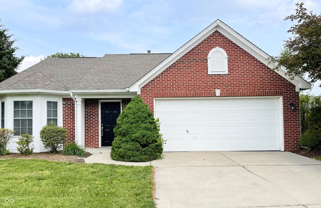 1173 Carlton Ct, Greenwood, IN 46143 - view of front of home with brick siding, a shingled roof, concrete driveway, and an attached garage