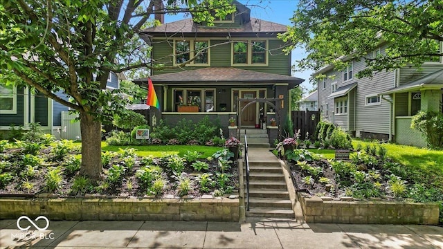 4046 N Park Ave, Indianapolis, IN 46205 - american foursquare style home featuring covered porch, roof with shingles, and stairs