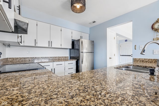 8158 Shorewalk Dr Unit F, Indianapolis, IN 46236 - kitchen with freestanding refrigerator, white cabinetry, dark stone countertops, range hood, and range