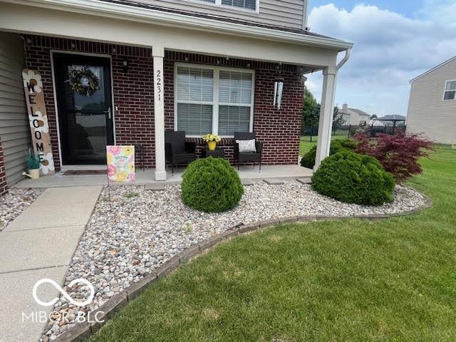 2231 Abbey St, Brownsburg, IN 46112 - entrance to property with a porch, a lawn, and brick siding