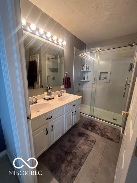 2231 Abbey St, Brownsburg, IN 46112 - full bath with a stall shower, double vanity, tile patterned floors, and a textured ceiling