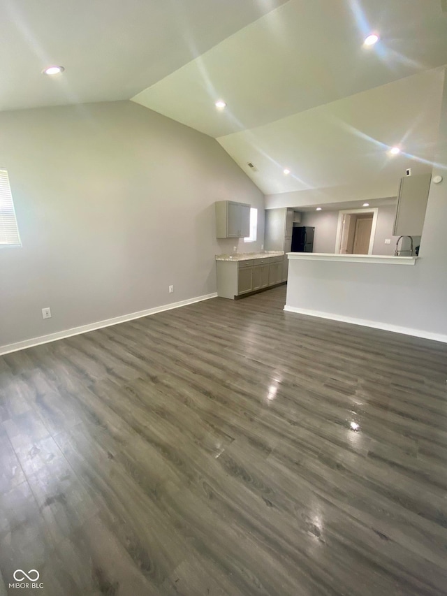 3464 N Bancroft St, Indianapolis, IN 46218 - unfurnished living room with lofted ceiling, dark wood-style floors, and recessed lighting