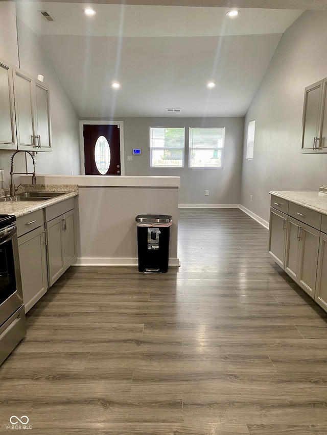 3464 N Bancroft St, Indianapolis, IN 46218 - kitchen with vaulted ceiling, electric range, gray cabinets, dark wood-style flooring, and a peninsula