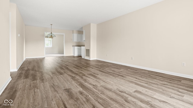 1309 Wyoming Way, Anderson, IN 46013 - unfurnished living room with wood finished floors and a chandelier