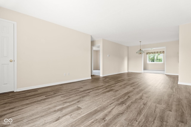 1309 Wyoming Way, Anderson, IN 46013 - unfurnished living room featuring wood finished floors and a chandelier