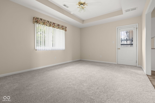 1309 Wyoming Way, Anderson, IN 46013 - spare room featuring carpet floors, a ceiling fan, and a tray ceiling