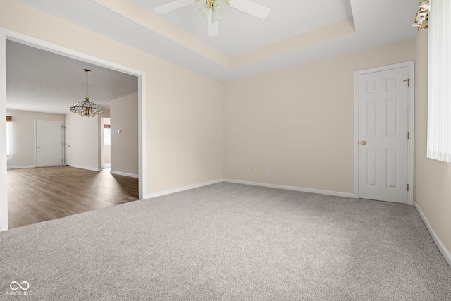 1309 Wyoming Way, Anderson, IN 46013 - spare room with carpet flooring, a ceiling fan, a chandelier, and a tray ceiling