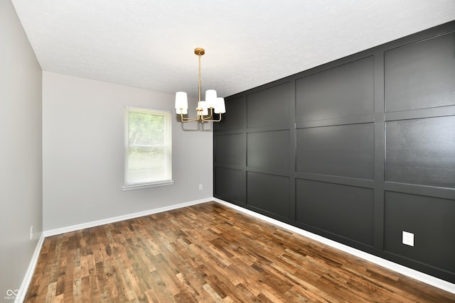 5759 Columbia Cir S, Greenwood, IN 46142 - empty room featuring a decorative wall, a chandelier, and dark wood-style flooring