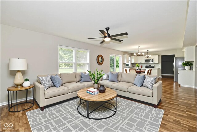 5759 Columbia Cir S, Greenwood, IN 46142 - living area with healthy amount of natural light, a ceiling fan, dark wood-style floors, and a chandelier