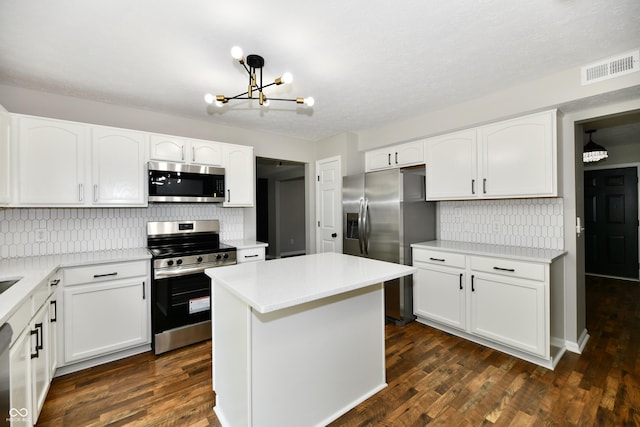 5759 Columbia Cir S, Greenwood, IN 46142 - kitchen featuring appliances with stainless steel finishes, a chandelier, backsplash, and white cabinetry