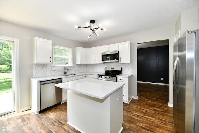 5759 Columbia Cir S, Greenwood, IN 46142 - kitchen featuring appliances with stainless steel finishes, a chandelier, tasteful backsplash, white cabinets, and dark wood-style flooring