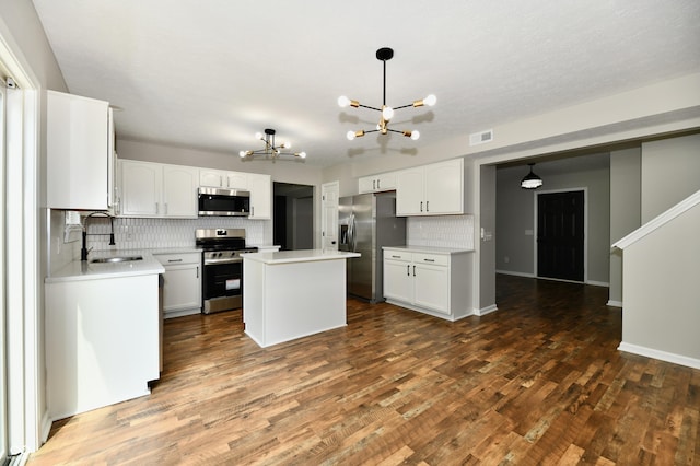 5759 Columbia Cir S, Greenwood, IN 46142 - kitchen featuring stainless steel appliances, a chandelier, decorative backsplash, a center island, and dark wood-type flooring