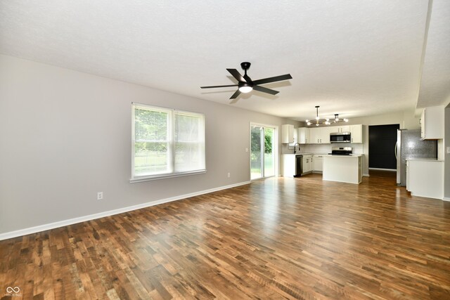 5759 Columbia Cir S, Greenwood, IN 46142 - unfurnished living room with dark wood finished floors, a ceiling fan, and a chandelier