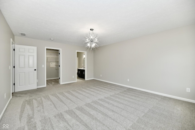 5759 Columbia Cir S, Greenwood, IN 46142 - unfurnished bedroom with carpet floors, a walk in closet, a chandelier, ensuite bath, and a closet