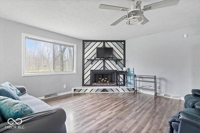 6120 E Southport Rd, Indianapolis, IN 46237 - living area with ceiling fan, wood finished floors, a textured ceiling, and a fireplace
