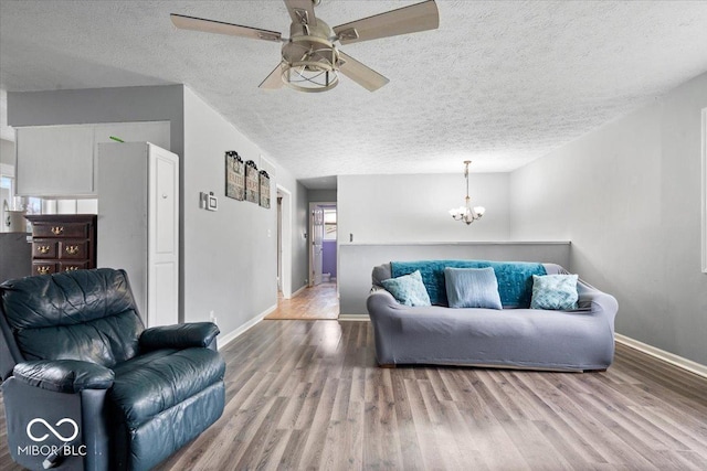 6120 E Southport Rd, Indianapolis, IN 46237 - living area with a chandelier, wood finished floors, a ceiling fan, and a textured ceiling