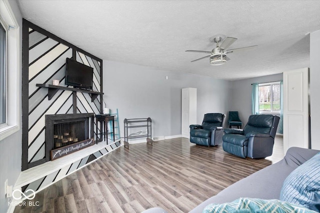 6120 E Southport Rd, Indianapolis, IN 46237 - living area with wood finished floors, ceiling fan, a textured ceiling, and a fireplace with raised hearth
