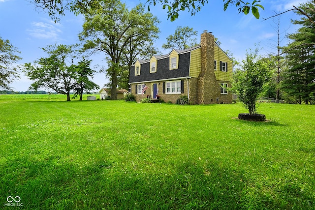 13041 S Finer St, Pimento, IN 47866 - dutch colonial featuring a gambrel roof, a chimney, a front yard, and brick siding