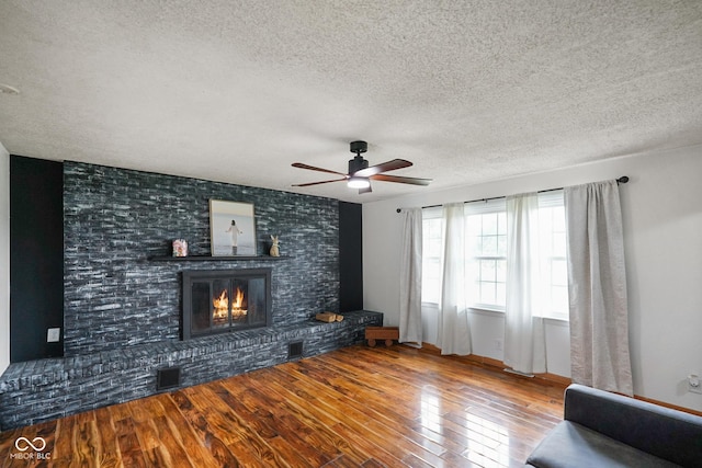 13041 S Finer St, Pimento, IN 47866 - living room with a textured ceiling, wood-type flooring, ceiling fan, and a fireplace