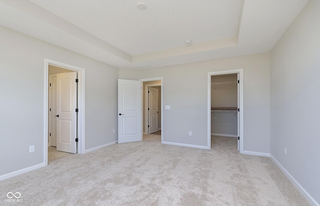 9737 Oleander Dr, Fishers, IN 46250 - unfurnished bedroom with light carpet, a raised ceiling, and a walk in closet