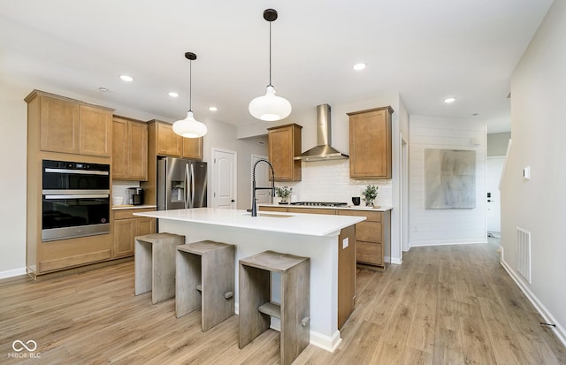 9737 Oleander Dr, Fishers, IN 46250 - kitchen featuring wall chimney range hood, stainless steel fridge, decorative backsplash, light wood-style flooring, and recessed lighting