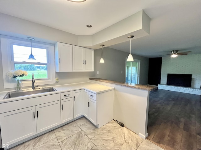 15841 E 265 N, Columbus, IN 47203 - kitchen with a peninsula, white cabinets, a ceiling fan, and hanging light fixtures