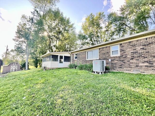 15841 E 265 N, Columbus, IN 47203 - view of front of property with a sunroom, a storage unit, brick siding, and a front lawn