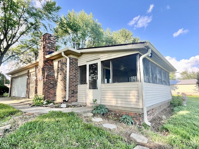 15841 E 265 N, Columbus, IN 47203 - view of front of house with a garage, a sunroom, a chimney, and brick siding