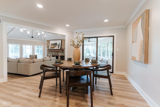14407 Bryn Mawr Dr, Fishers, IN 46038 - dining space with light wood-type flooring, crown molding, a fireplace, recessed lighting, and a chandelier