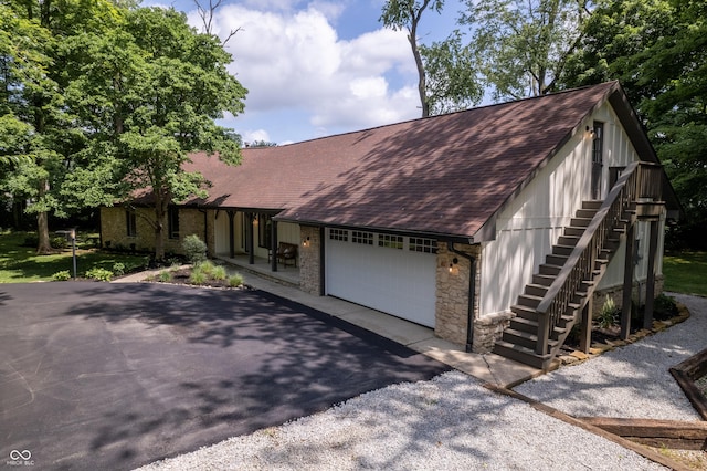14407 Bryn Mawr Dr, Fishers, IN 46038 - view of front of house with roof with shingles, stone siding, an attached garage, asphalt driveway, and stairs